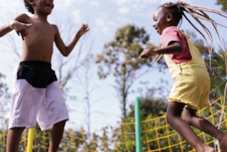 Child happily jumping on a 1.40m black trampoline with reinforced frame in a sunny backyard