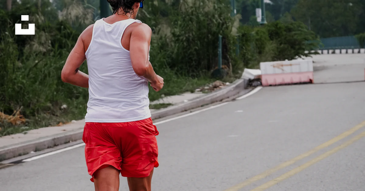 Un Running A man running down the street in red shorts photo – Free Man Image on ...