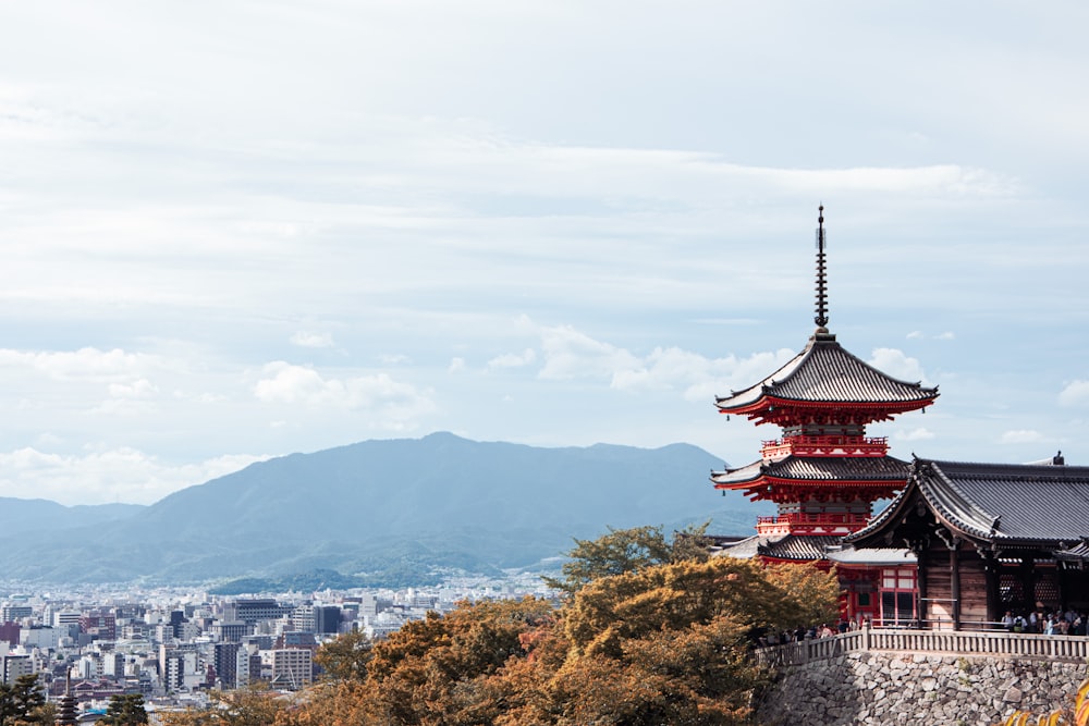 a tall red building sitting on top of a lush green hillside