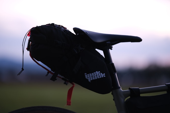 A budget seat bag strapped to a bike saddle on a dirt trail