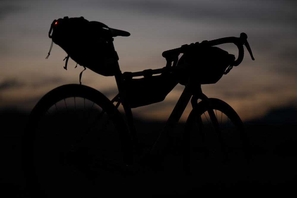 a silhouette of a bike with a bag on the back