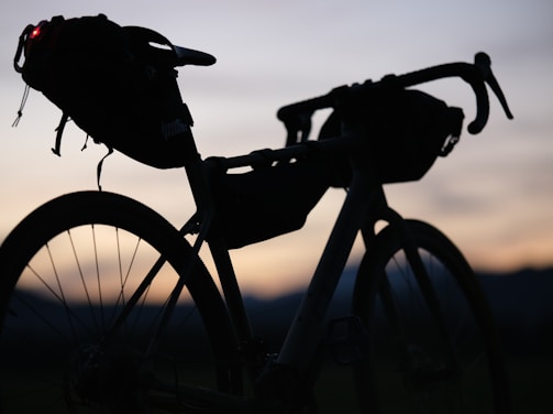 a silhouette of a bike with a bag on the back of it