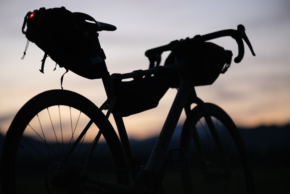 a silhouette of a bike with a bag on the back of it