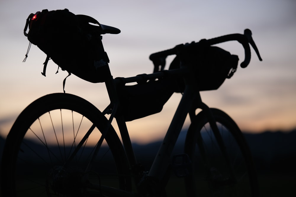 a silhouette of a bike with a back pack on it