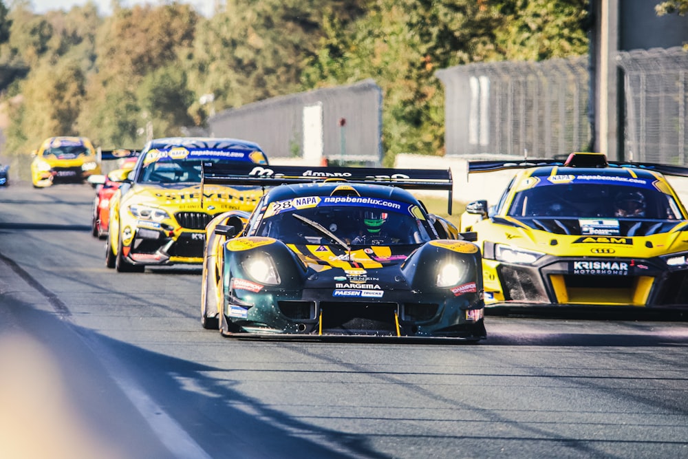 a group of racing cars driving down a race track