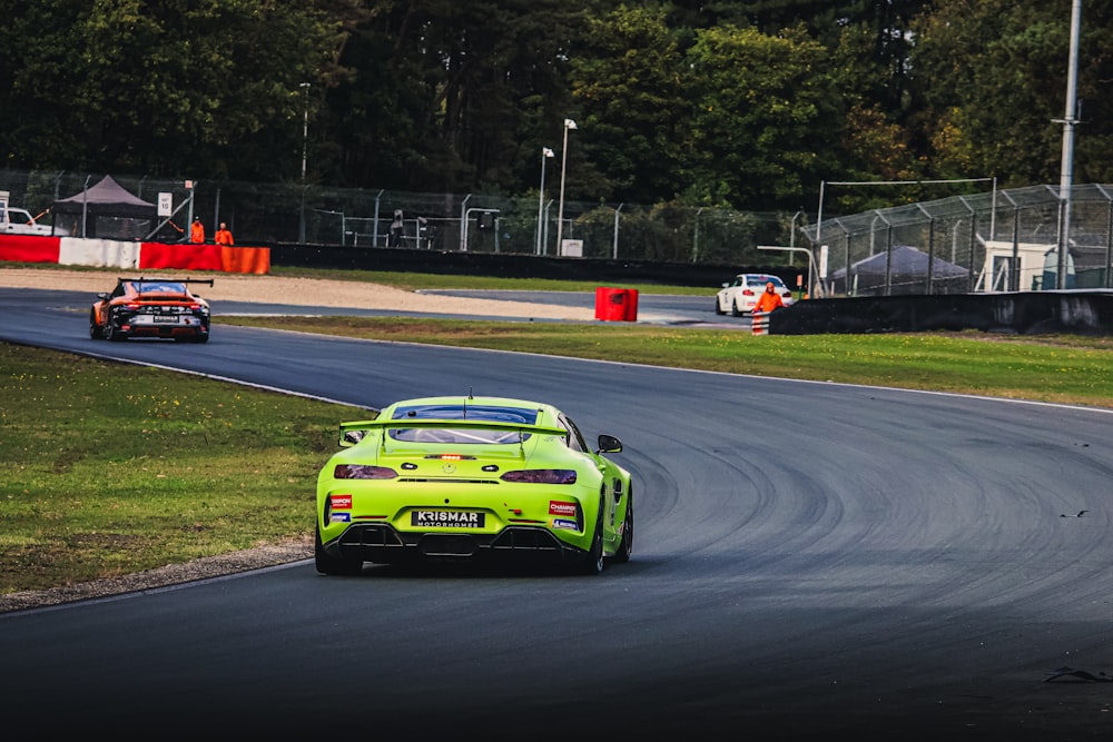 a green sports car driving on a race track