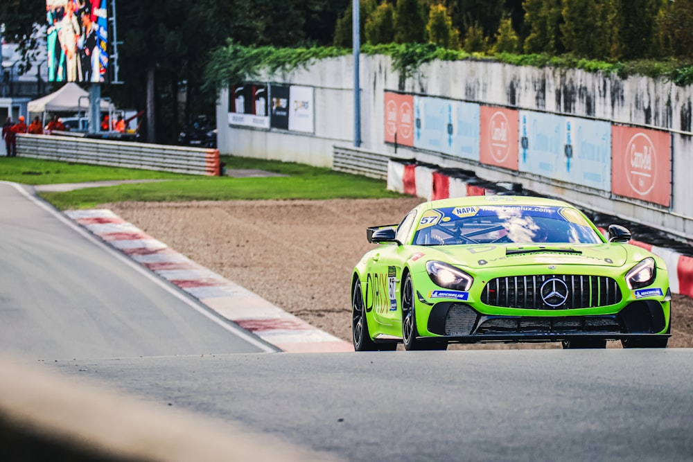 a green sports car driving down a race track
