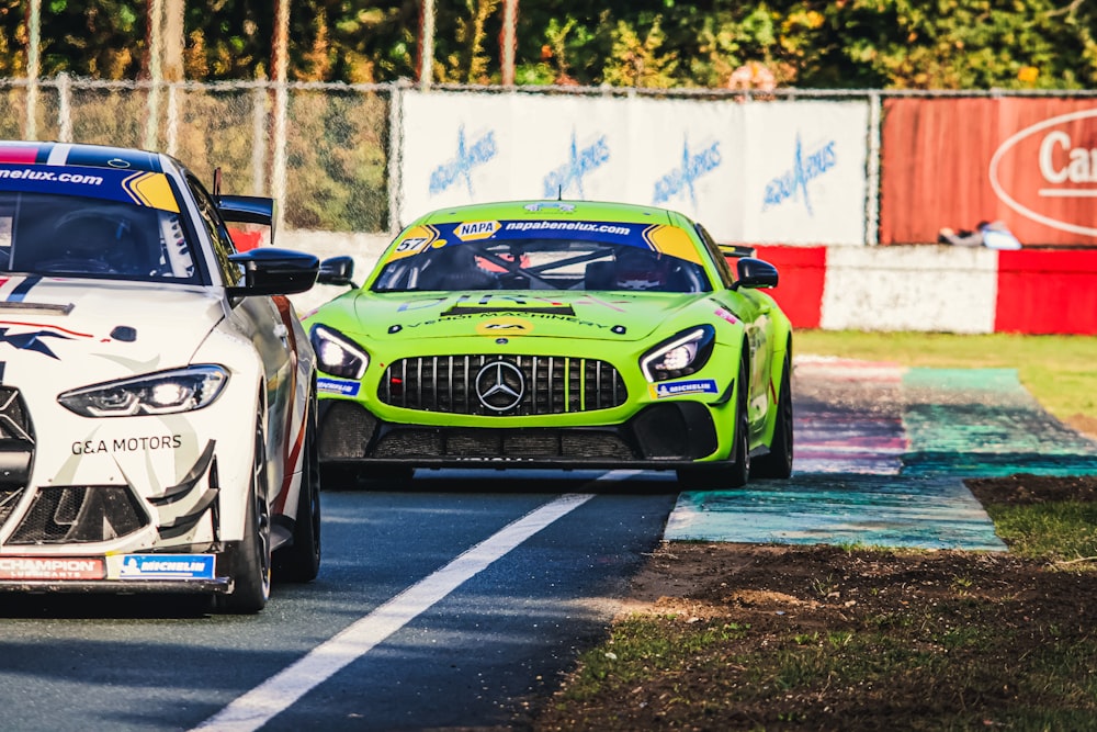 a couple of cars driving down a race track