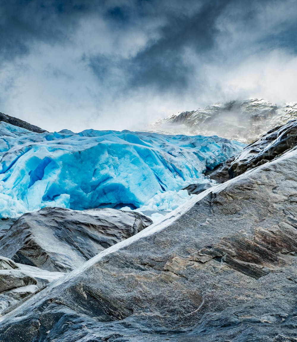 a large blue glacier on a cloudy day