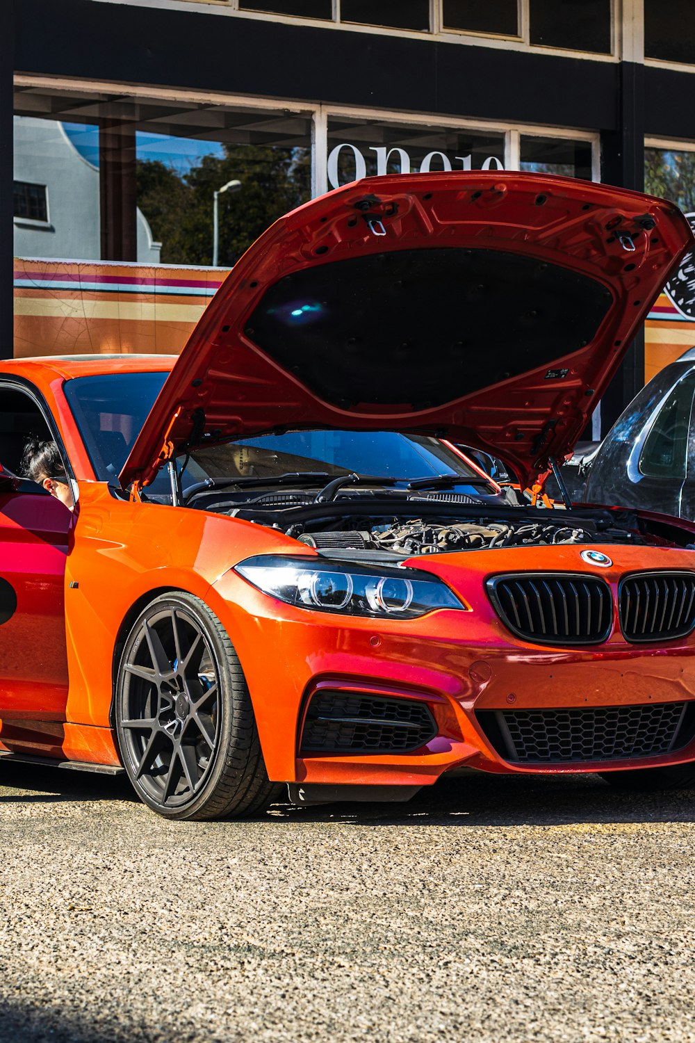 an orange bmw car with its hood open