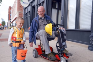 an older man and a young boy on a scooter