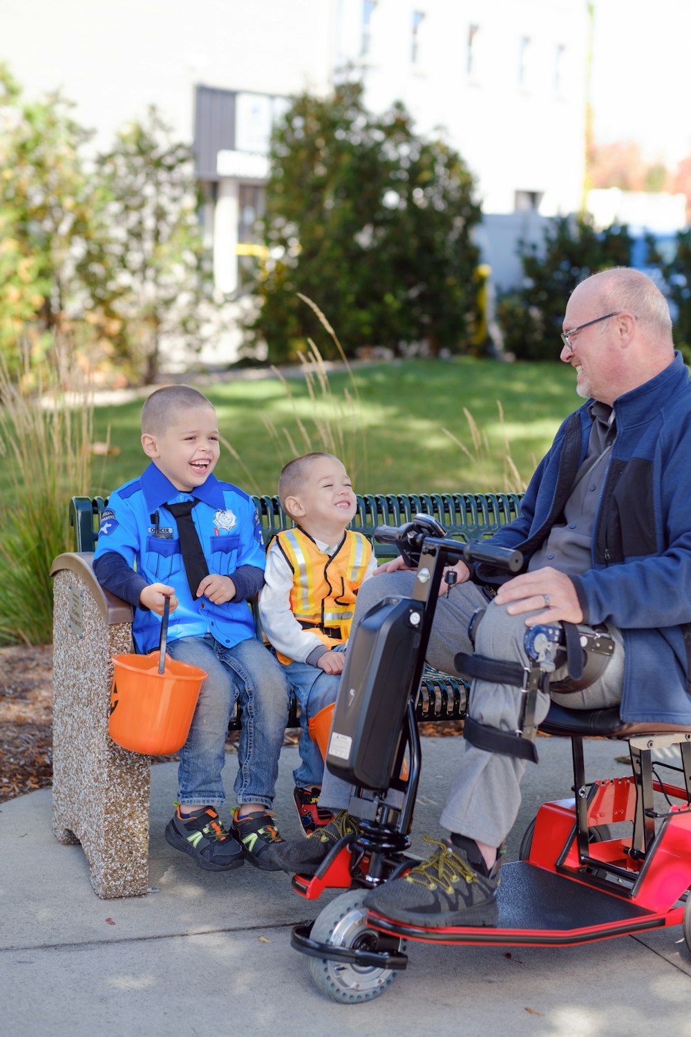 a man sitting on a bench with two children