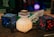 A collection of pixelated, Minecraft-themed objects, including a glowing potion bottle, blocks with blue and red accents, and various figurines resembling game elements.
