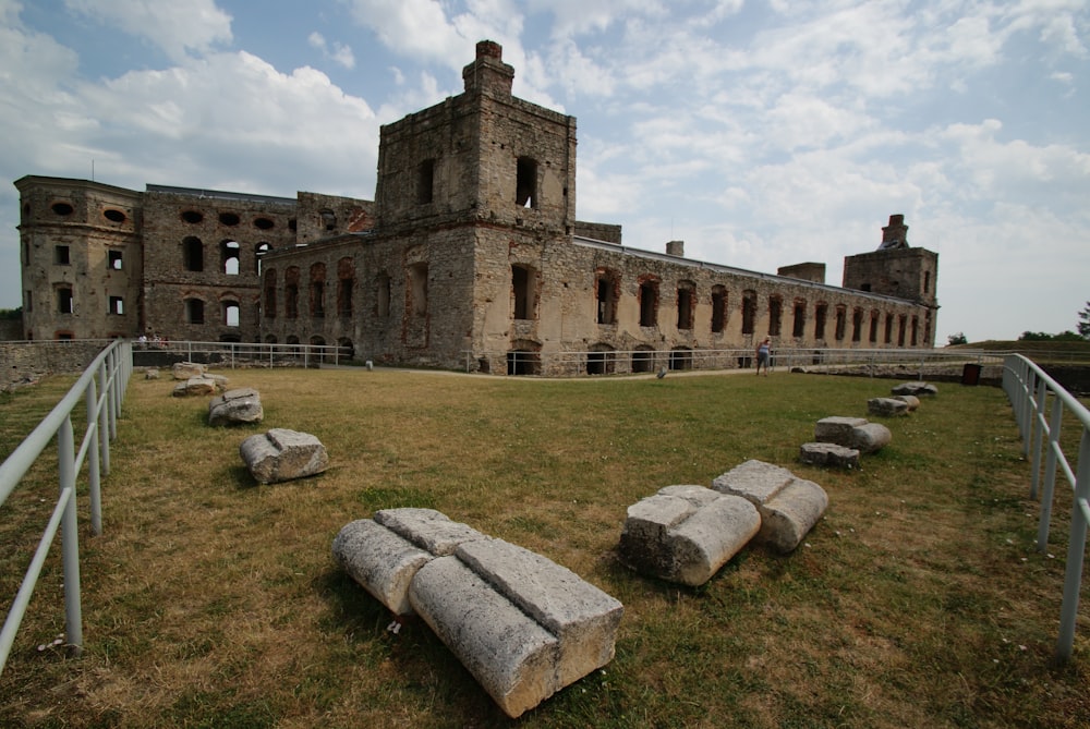 Un gran edificio de piedra situado en la parte superior de un exuberante campo verde