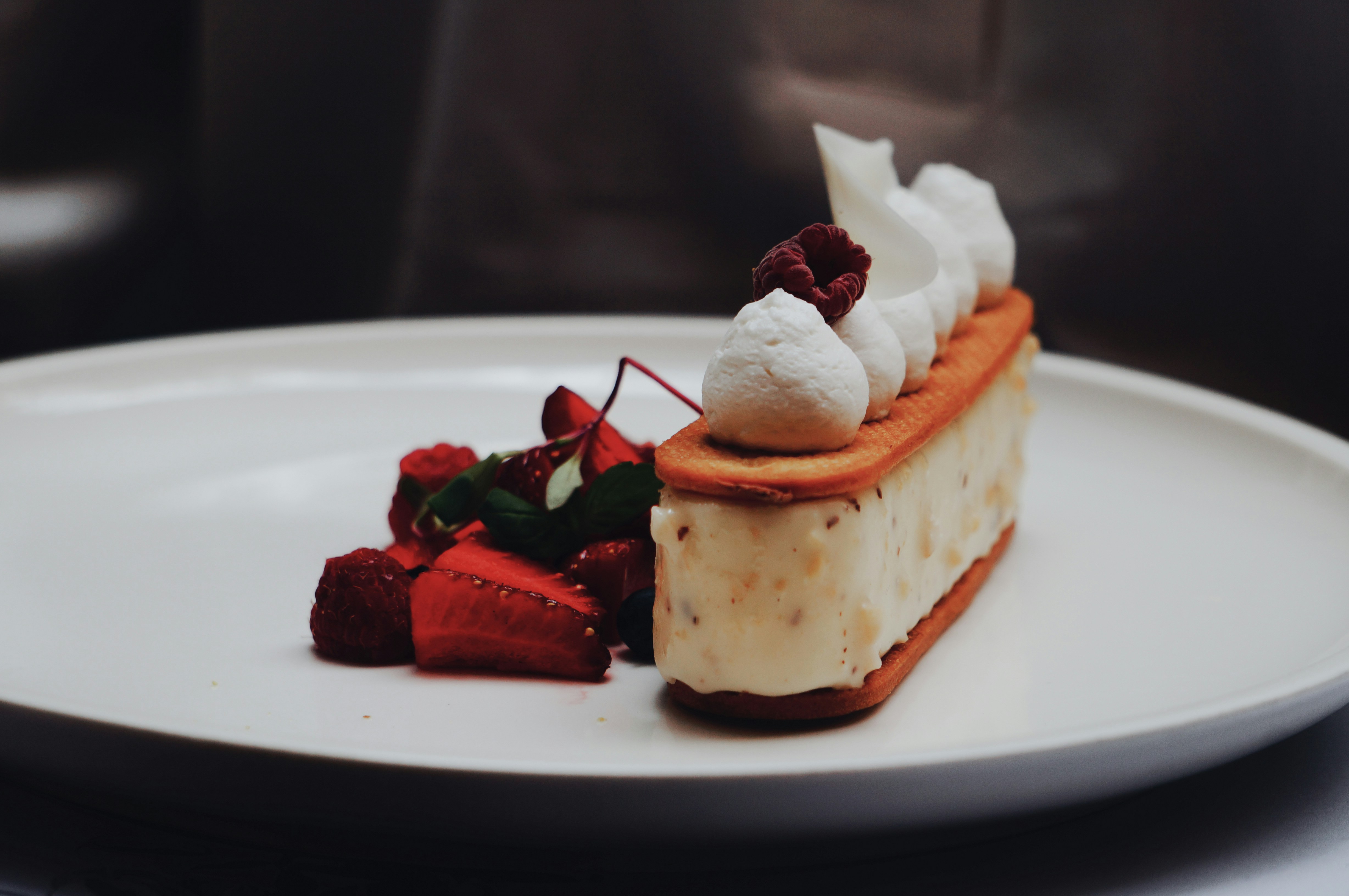 A piece of cake with whipped cream and strawberries on a plate