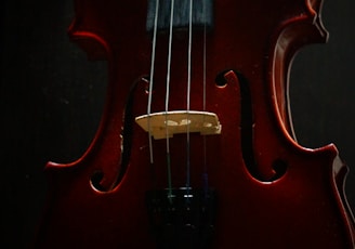 a red violin sitting on top of a table