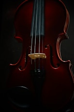 a red violin sitting on top of a table