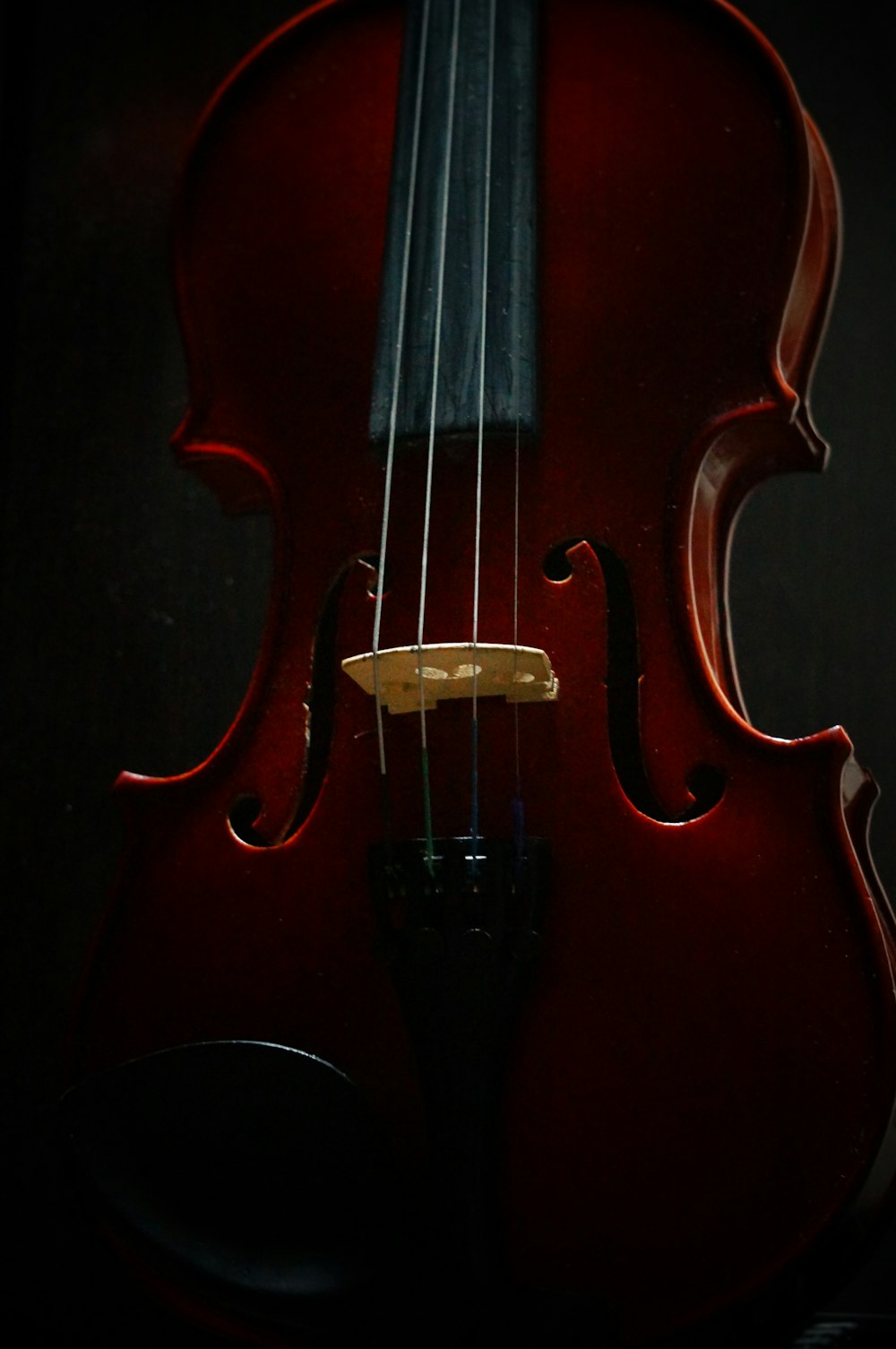a red violin sitting on top of a table