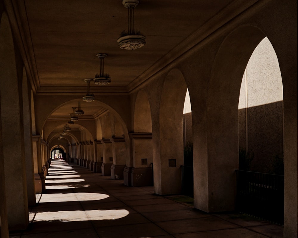 a long hallway with arched windows and a clock on the wall