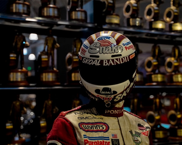 Group of racers celebrating on the podium with trophies and helmets