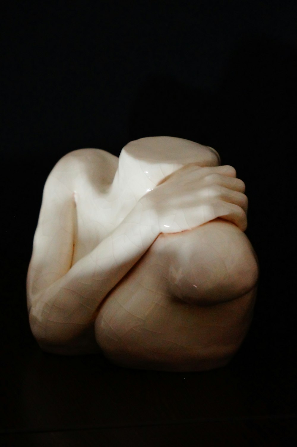 a sculpture of a woman with her arms wrapped around her body