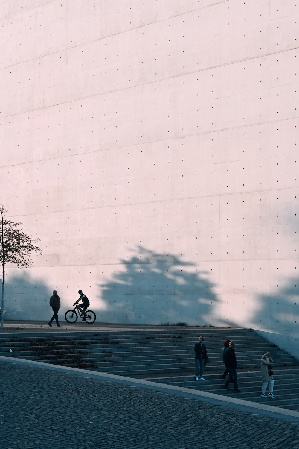 a group of people walking down a street next to a tall building