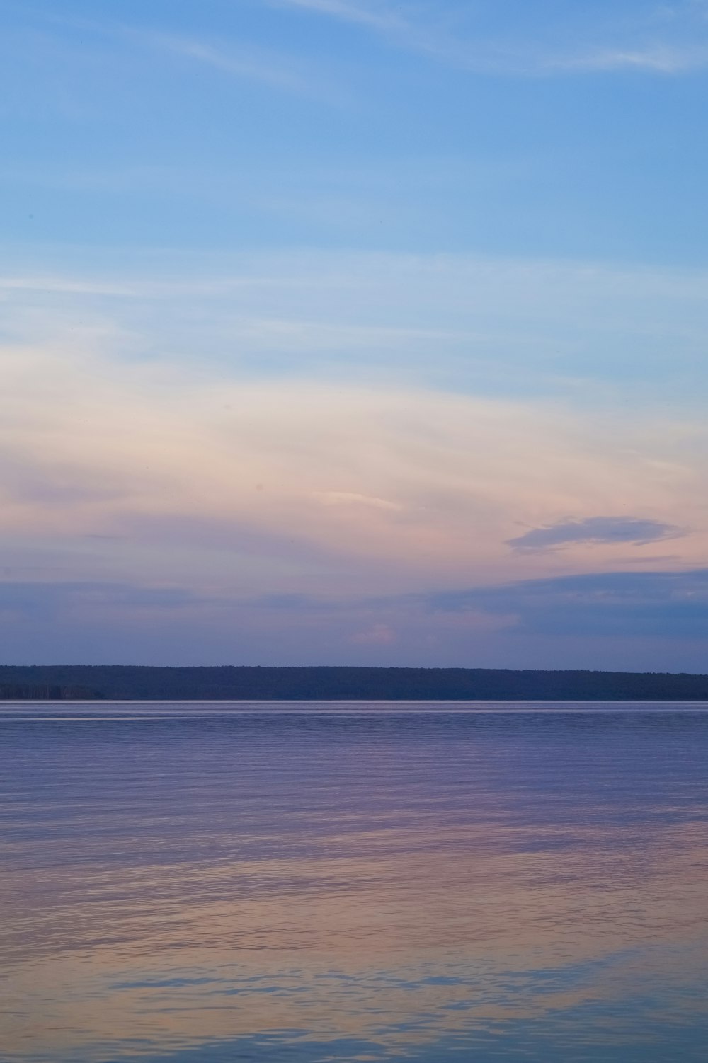 a large body of water sitting under a blue sky