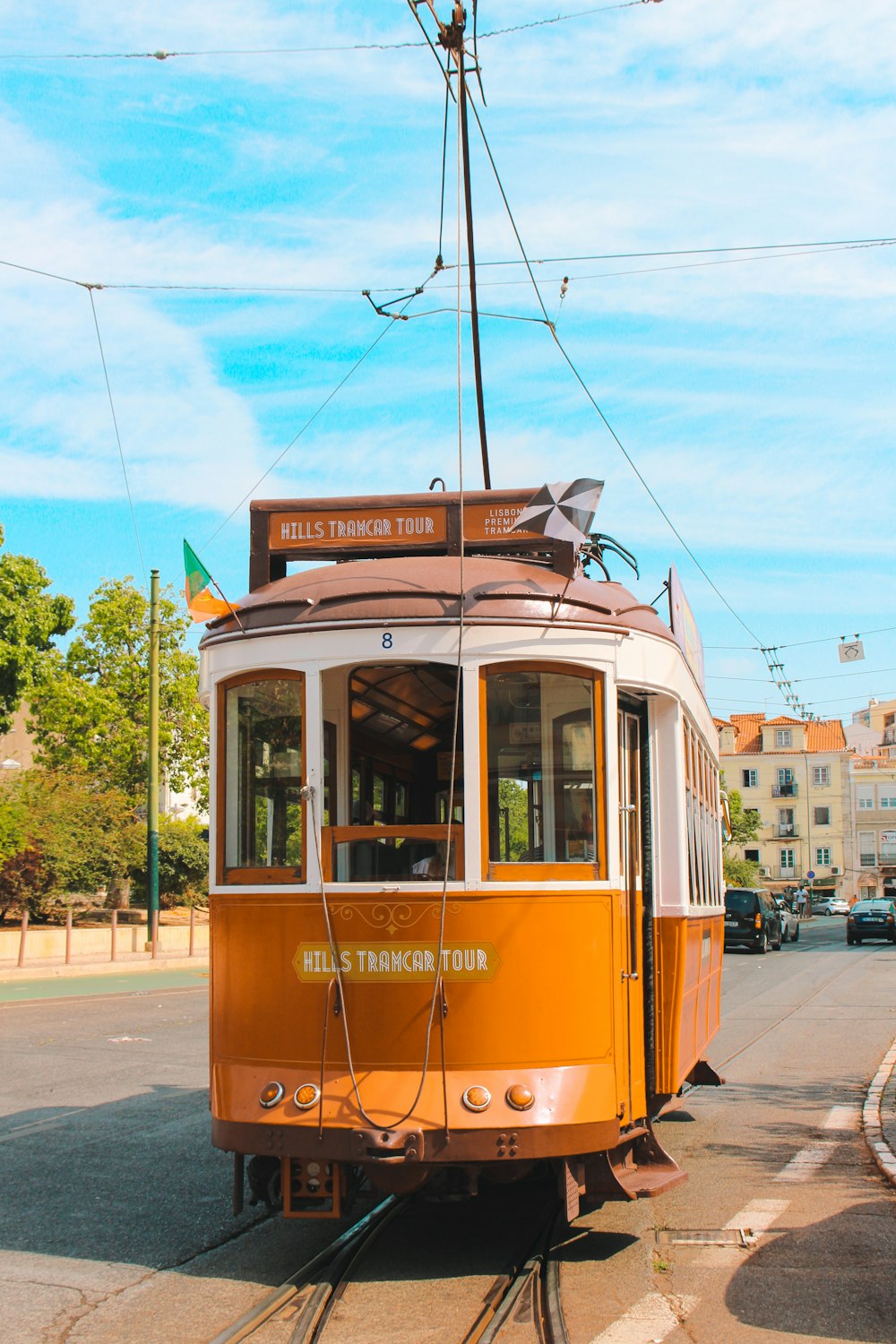 an orange trolley car on a city street