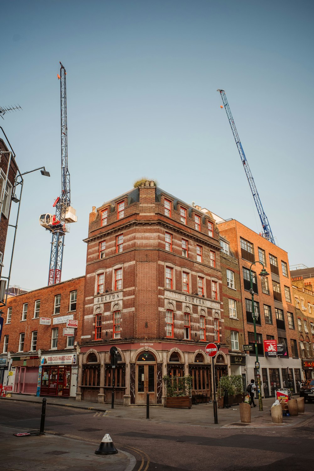 a large brick building with a crane in the background