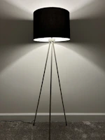 An elegant floor lamp with a sleek metal finish illuminating a cozy reading nook.