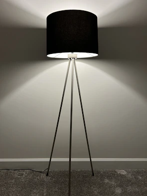 An elegant floor lamp with a sleek metal finish illuminating a cozy reading nook.