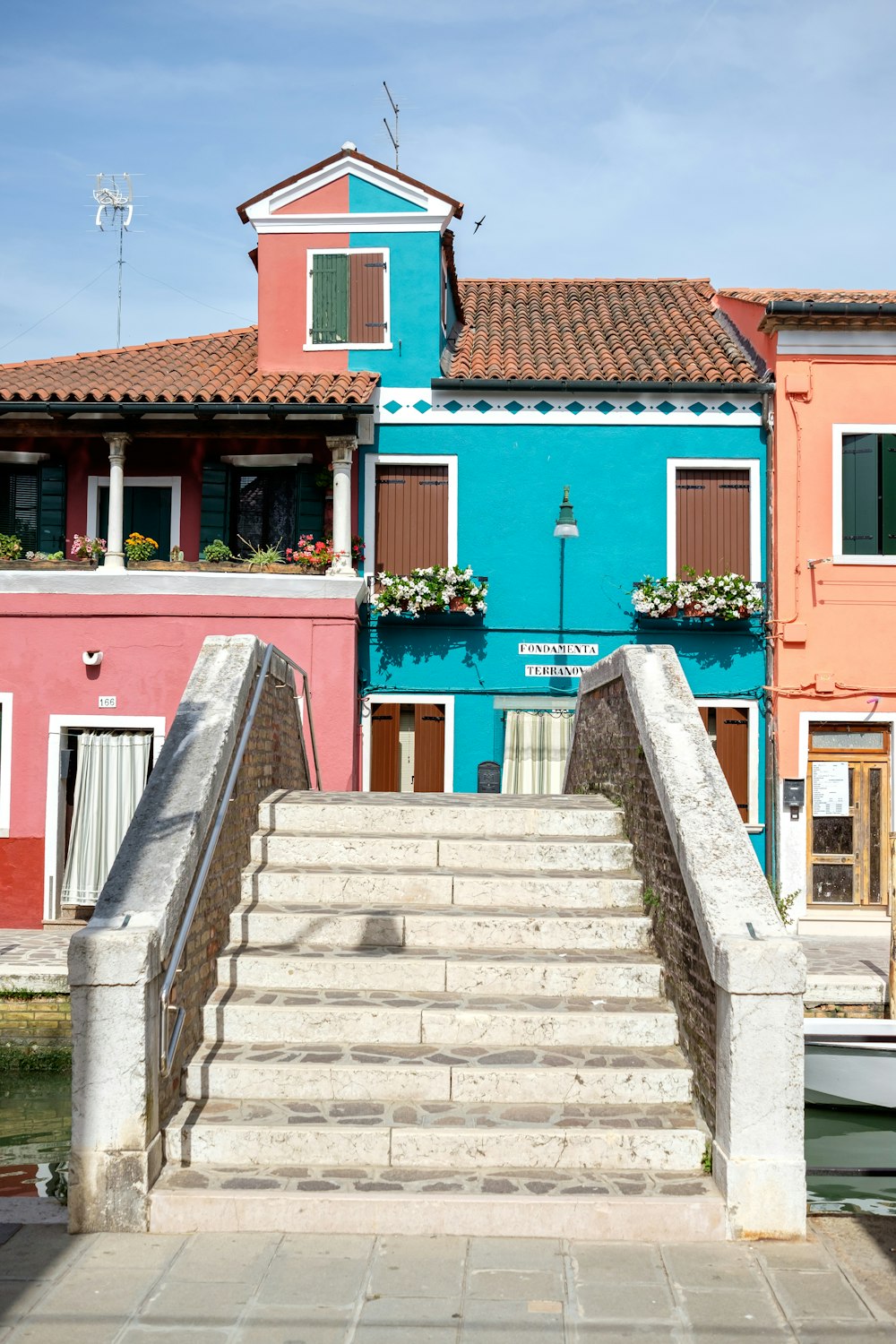 a row of colorful buildings with a boat in the water