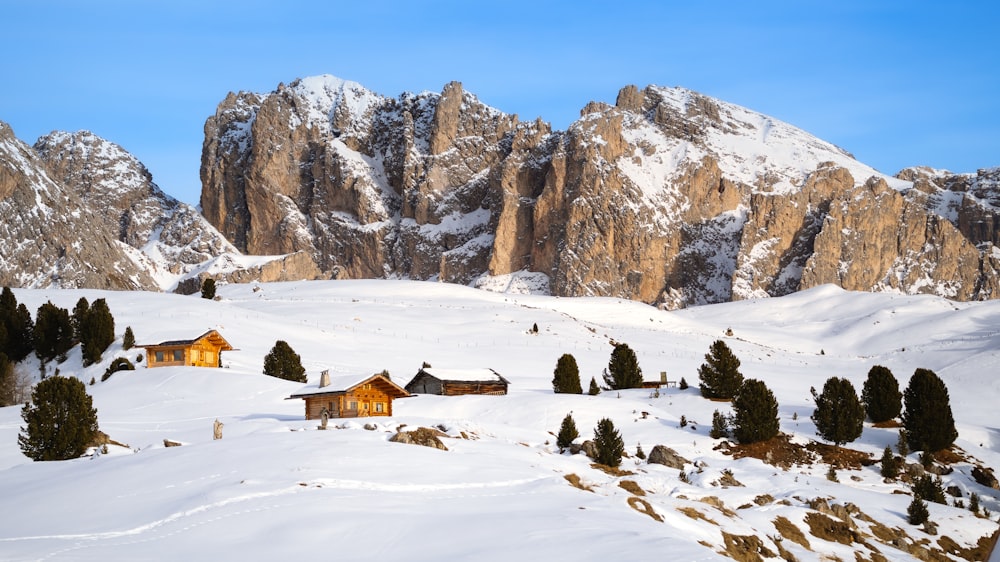 a snow covered mountain with a small cabin in the foreground