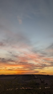 A stunning view of the English countryside with rolling hills and a vibrant sunset.