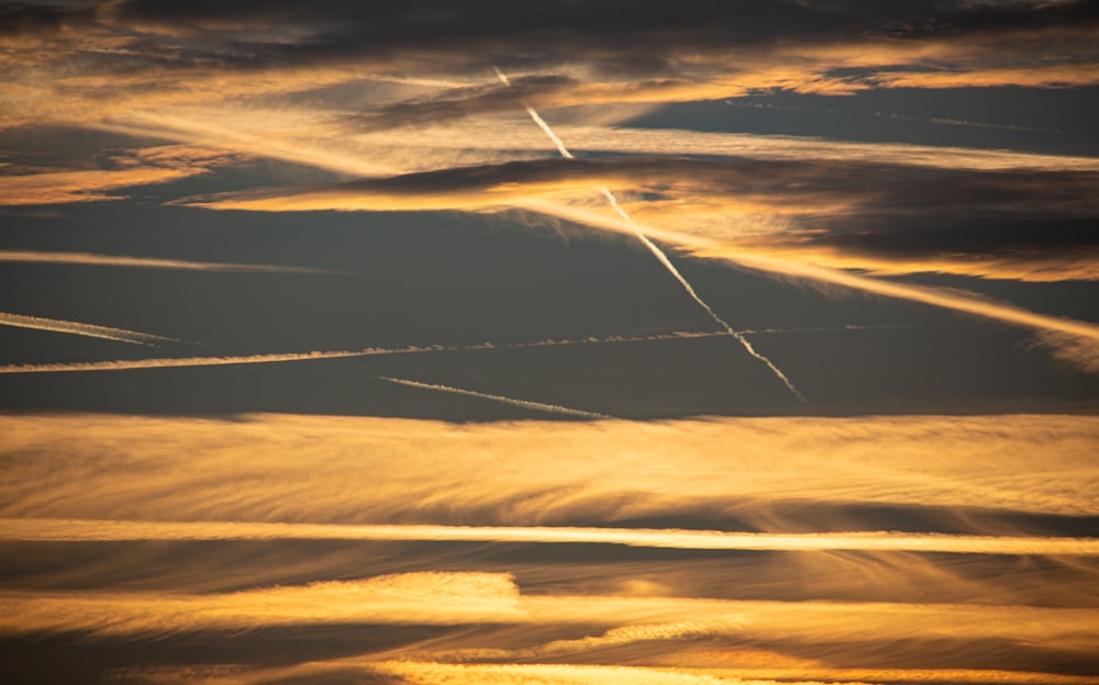 a group of contrails flying through a cloudy sky