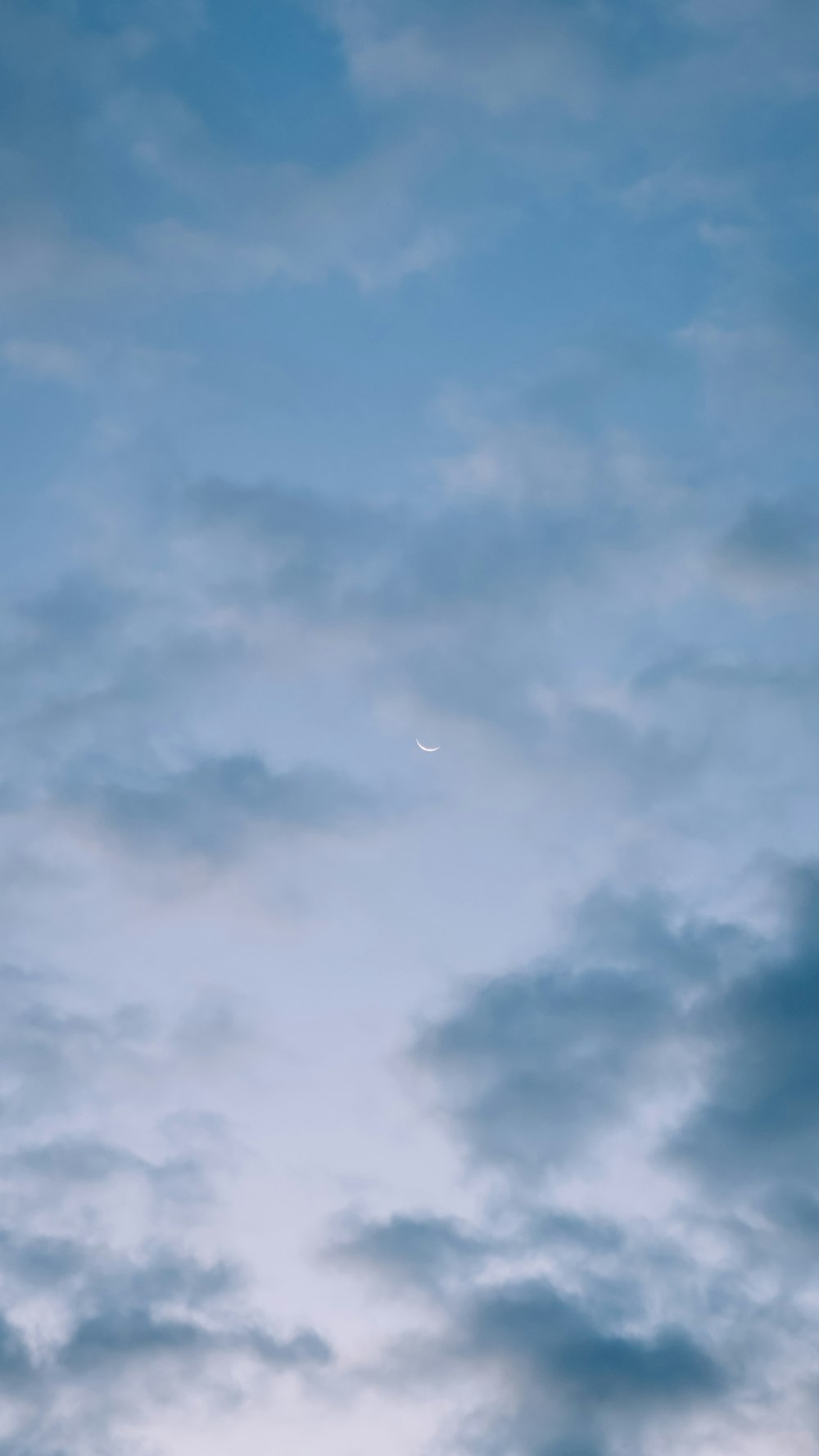 a plane flying through a cloudy blue sky