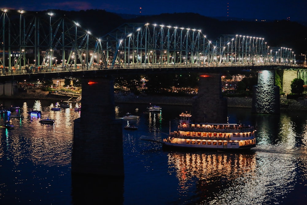 a large boat floating on top of a river under a bridge