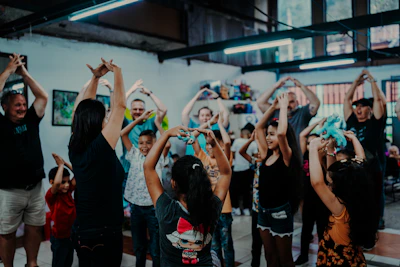 Families enjoying interactive movement games together in a colorful community center.