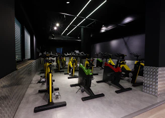 A vibrant group workout session in a sleek, green-accented studio filled with smiling, motivated members.