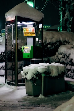 A friendly technician answering a phone call in a snowy village setting.