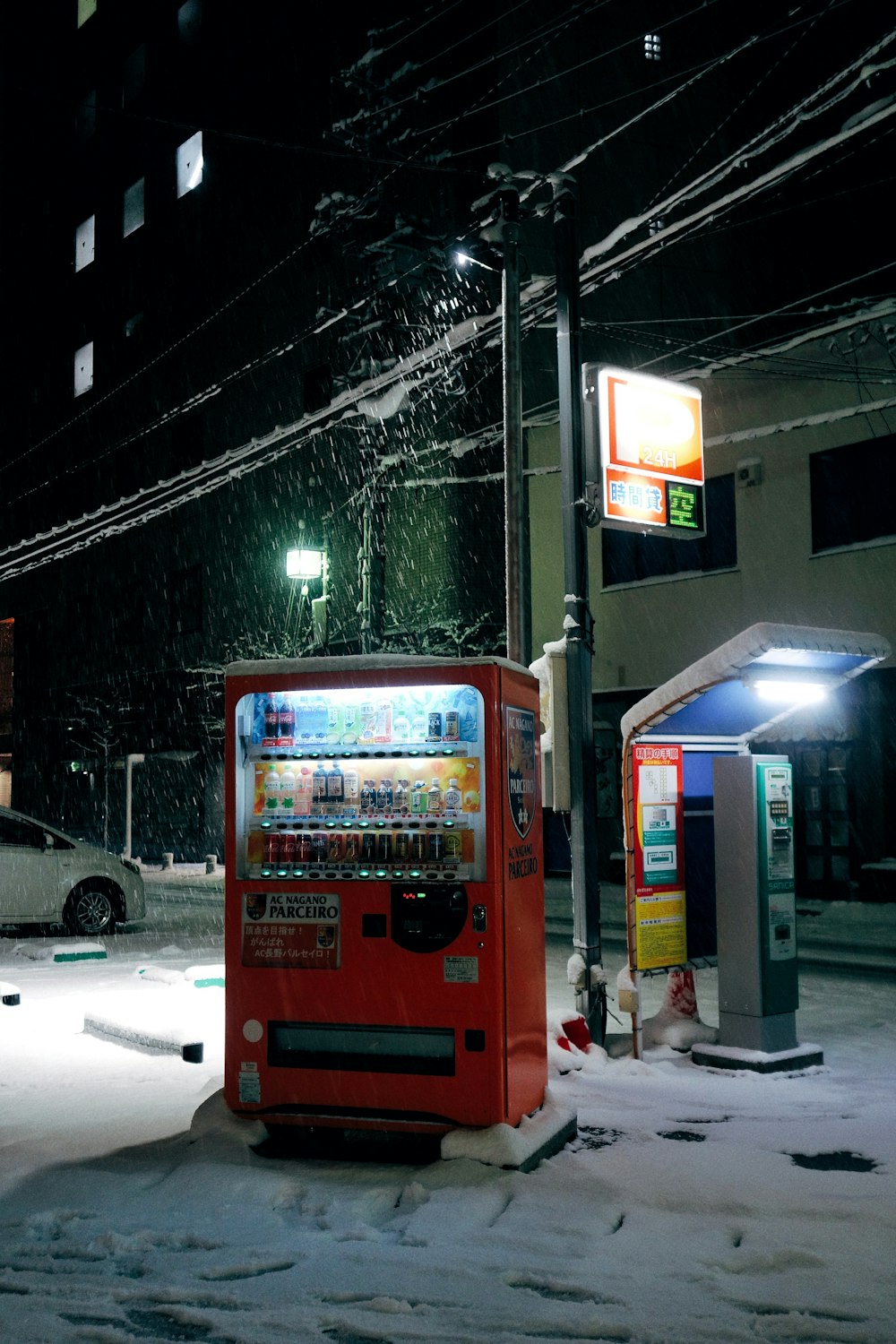 a red vending machine sitting on the side of a road