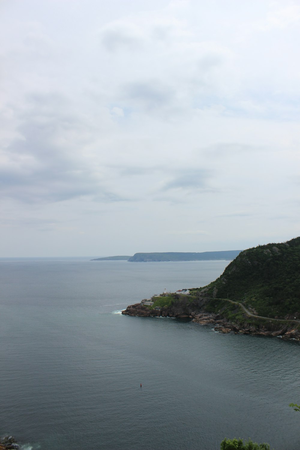 a body of water with a hill in the background