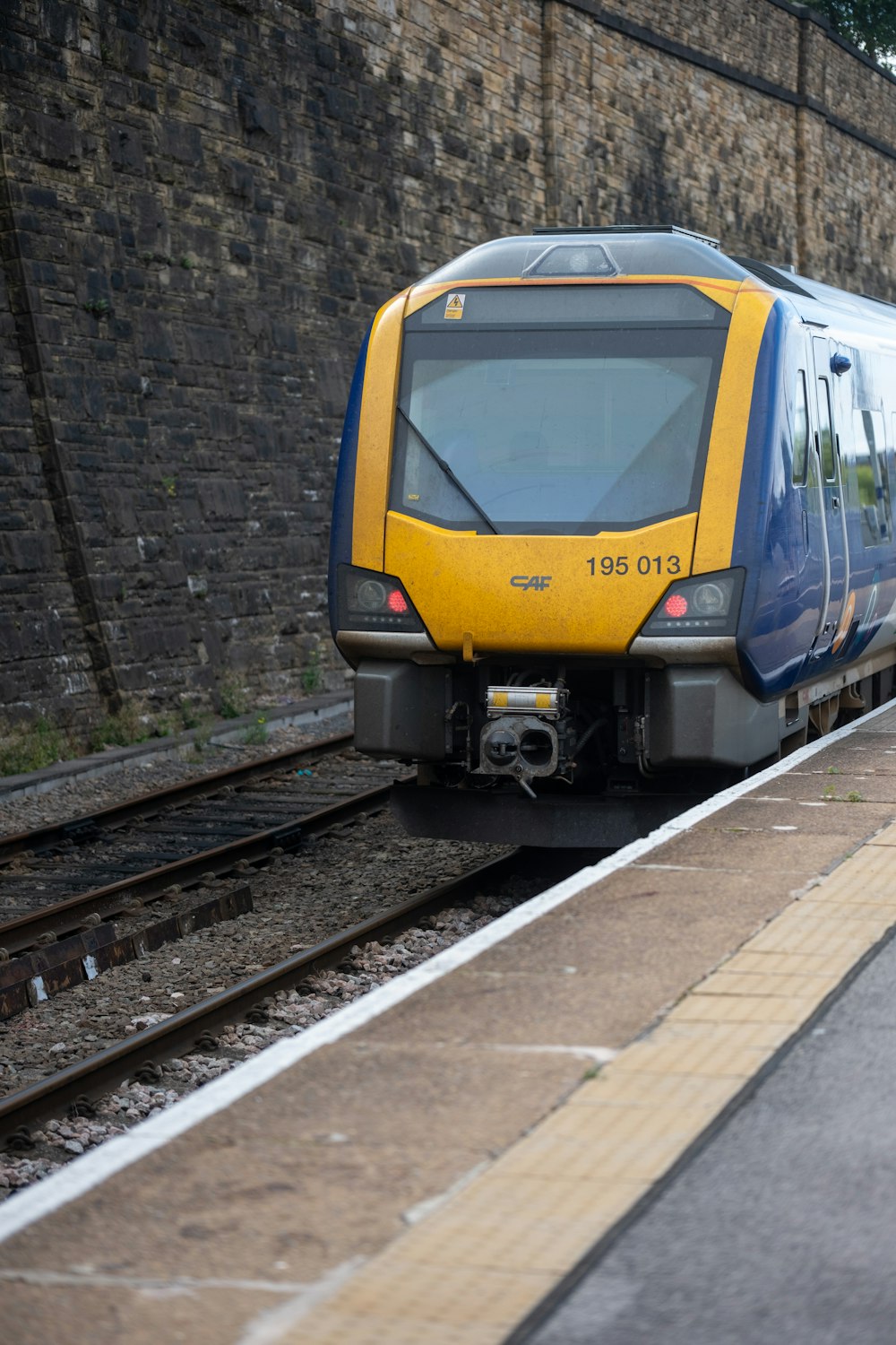 a yellow and blue train traveling down train tracks