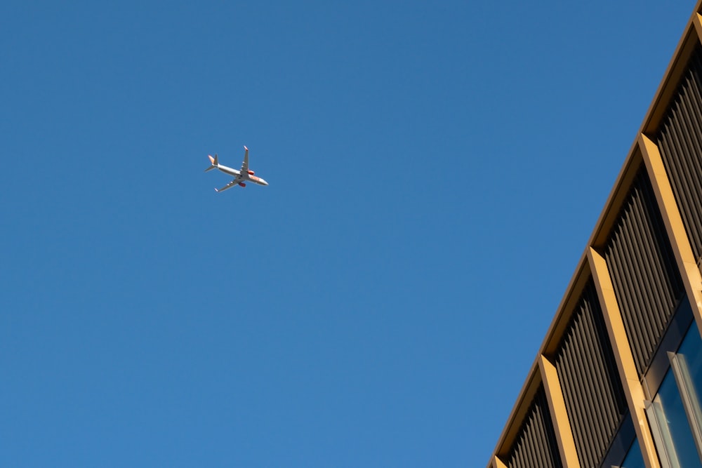 an airplane flying in the sky over a building