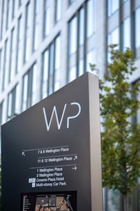 a sign for the wp in front of a tall building