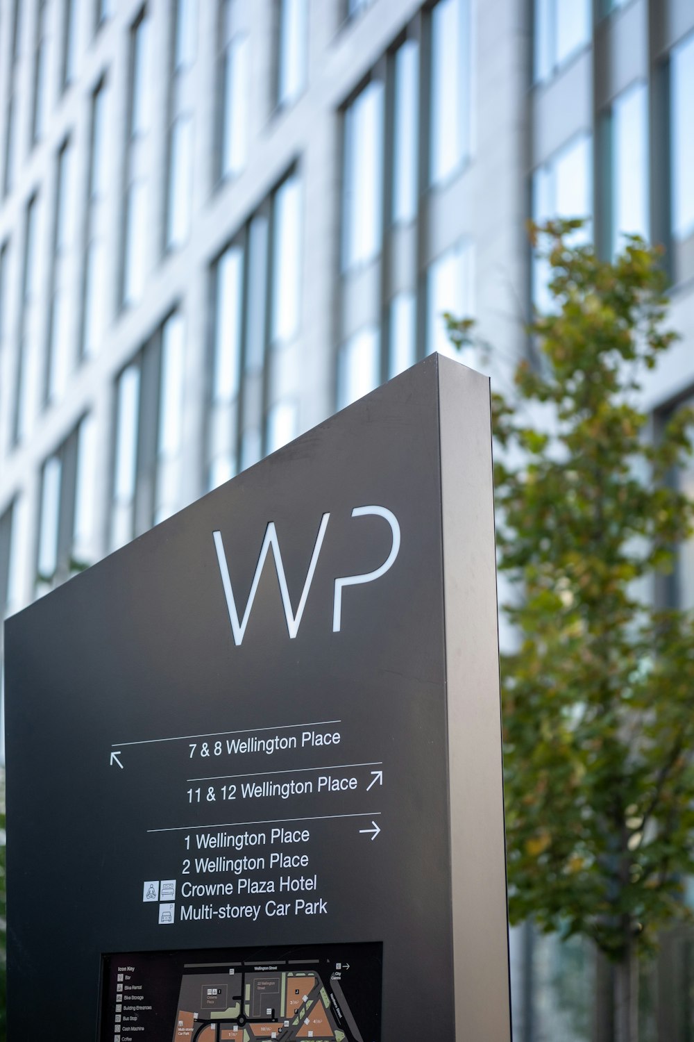 a sign for the wp in front of a tall building