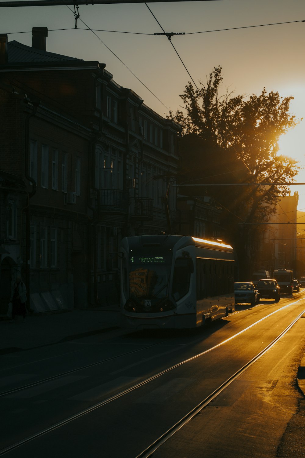 a bus driving down a street next to tall buildings