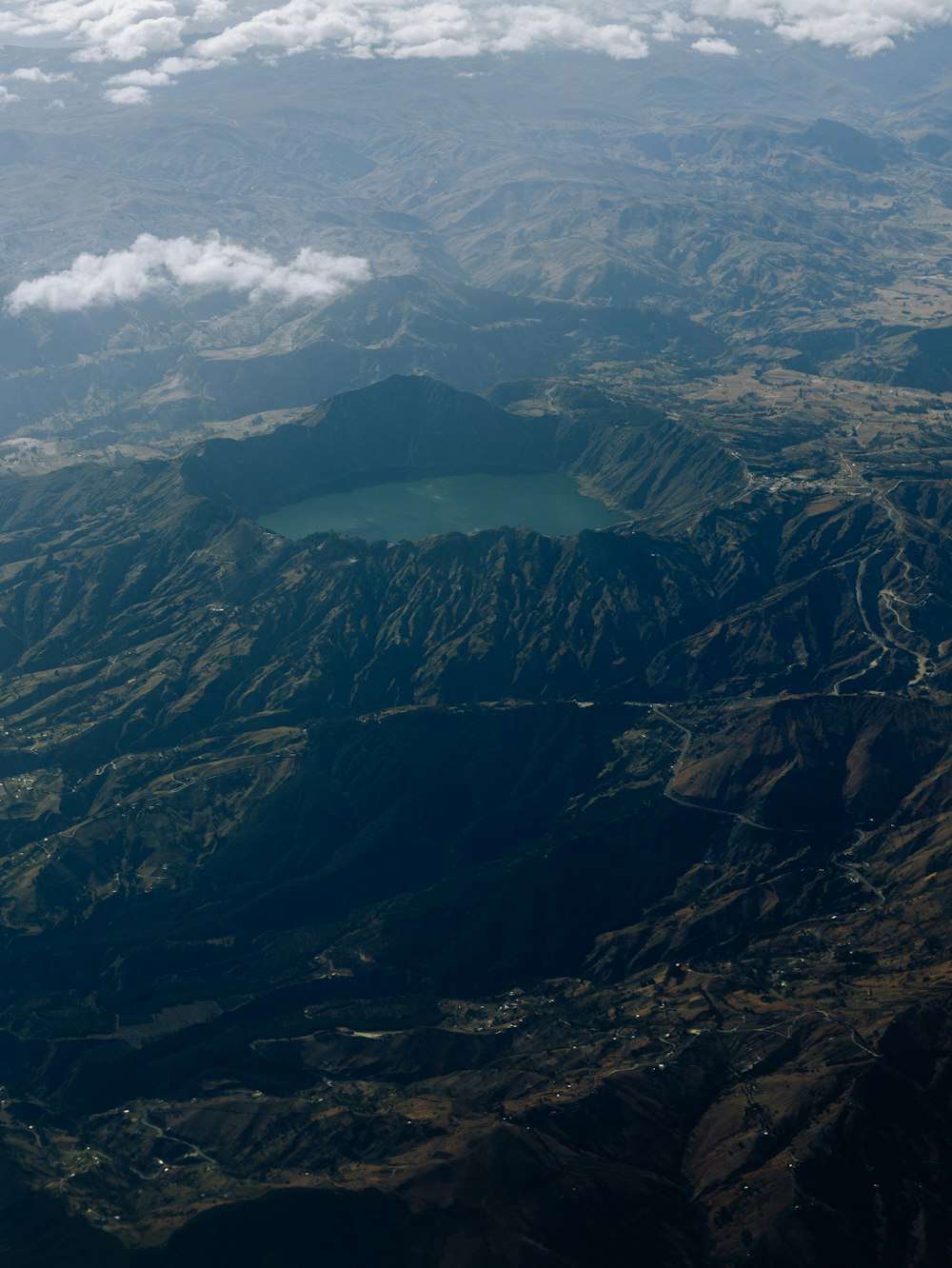 an aerial view of a mountain range with a lake in the middle