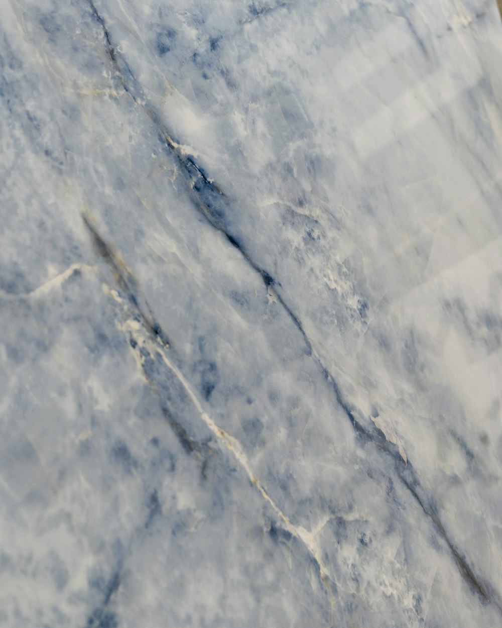 a close up of a marble surface with a white and blue pattern