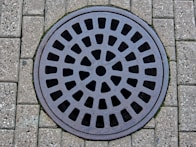 a manhole cover on a brick sidewalk